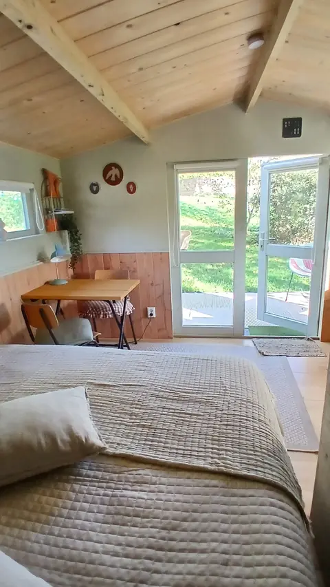 Bed, tafeltje en openslaande deuren in De Appel