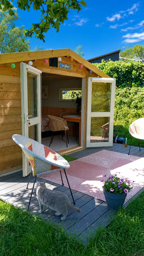 Terras van De Appel met een stoeltje en een kat die komt kijken