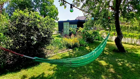 Groene hangmat tussen de bomen in de tuin
