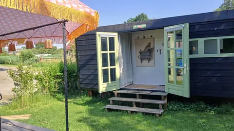 De Walnoot met de deuren open en een parasol ervoor